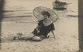 Bder/Einzelne/Frau mit Sonnenschirm am Wasser sitzend