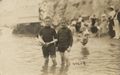 Jungen mit Holzschiff im Wasser stehend