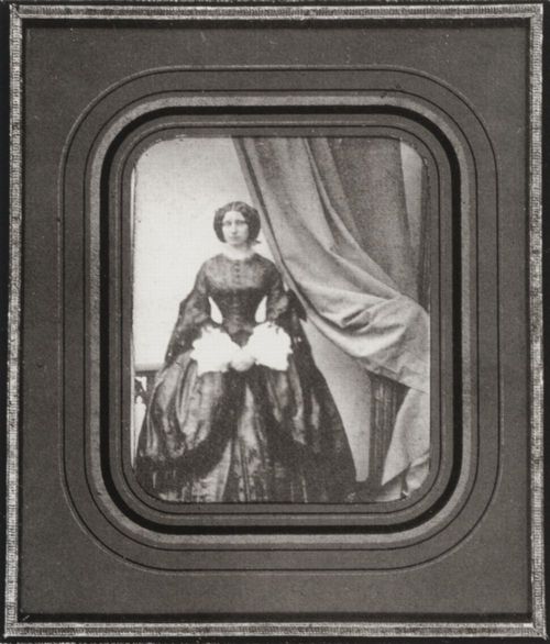 Krone, Hermann: Atelieraufnahme einer jungen Frau neben einem Vorhang, Dresden